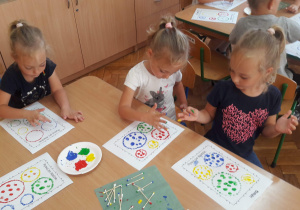 Dziewczynki malują przy stoliku farbami