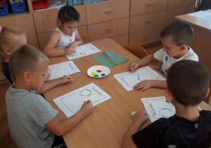 Przedszkolaki malują kropki patyczkiem