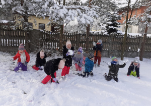 Przedszkolaki bawią się na śniegu