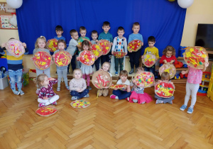 Dzieci trzymają papierowe pizze