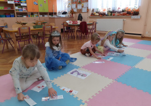 Dziewczynki układają puzzle związane z postaciami z bajek.