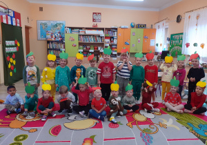 Dzieci z opaskami jabłek na głowie.