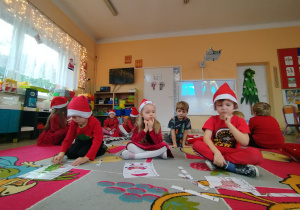 Przedszkolaki układająmikołajkowe puzzle.