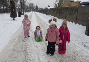 Dziewczynki jeżdżą na sankach