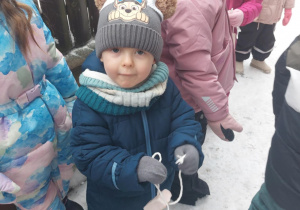 Dawidek wiesza słoninkę dla sikorek.